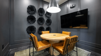 A modern dining room with a round table and chairs.